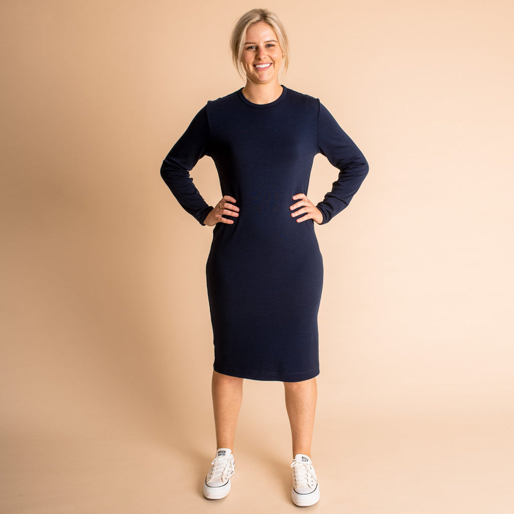 Woman wearing soft Australian Merino wool relaxed fitting long sleeve crew neck dress in navy. Designed as a relaxed fit and sitting around knee length. This style is perfect as a base to add other layers. Made in Australia at Woolerina's workrooms at Forbes in central west NSW.