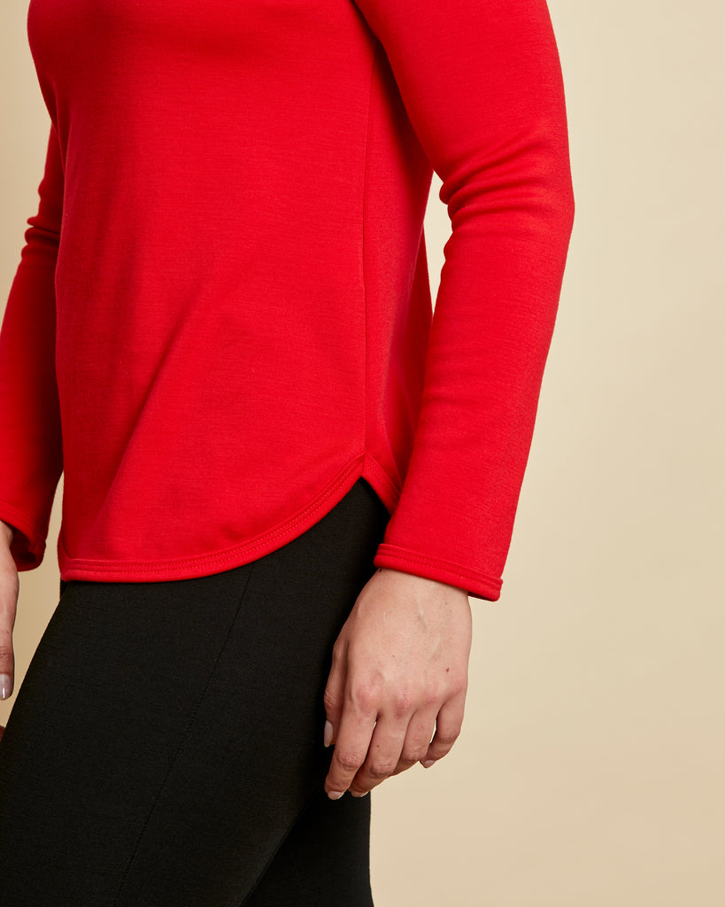 Woman wearing soft Australian Merino wool crew neck pullover in tomato red. Relaxed fitting, designed to wear over other layers as an outer layer or on its own next to the skin. Made in Australia at Woolerina's workrooms at Forbes in central west NSW.