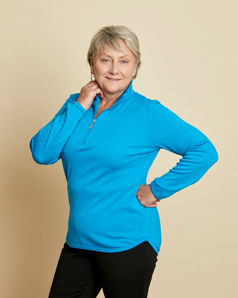 Woman wearing a soft Australian Merino wool pullover with a quarter zip in turquoise. Relaxed fitting, designed to wear over other layers as an outer layer or on its own next to the skin. Made in Australia at Woolerina's workroom at Forbes in central west NSW.